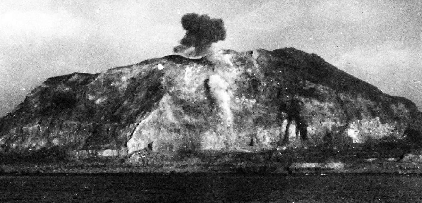 Planes strafing Iwo Jima, with Mt. Suribachi smoking from the bombs. U.S. Official Navy photograph, now in the collections of the National Archives.