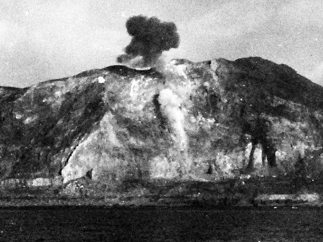 Planes strafing Iwo Jima, with Mt. Suribachi smoking from the bombs. U.S. Official Navy photograph, now in the collections of the National Archives.